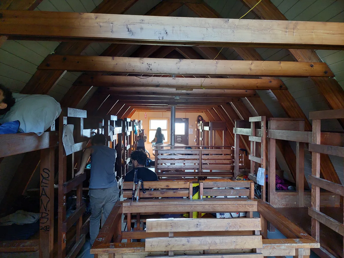 Wooden bunks beneath exposed rafters inside the Elfin Lakes cabin
