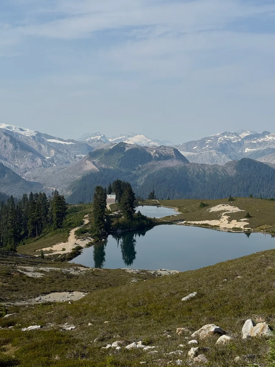 Two alpine lakes beneath a ridge of snowy mountains