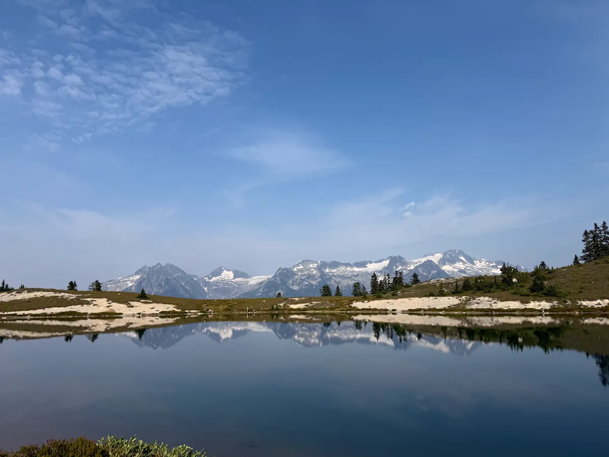 Snowy mountains and blue sky reflected in a still alpine lake
