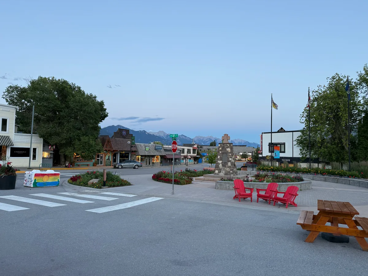 A village plaza with red chairs and mountains in the distance
